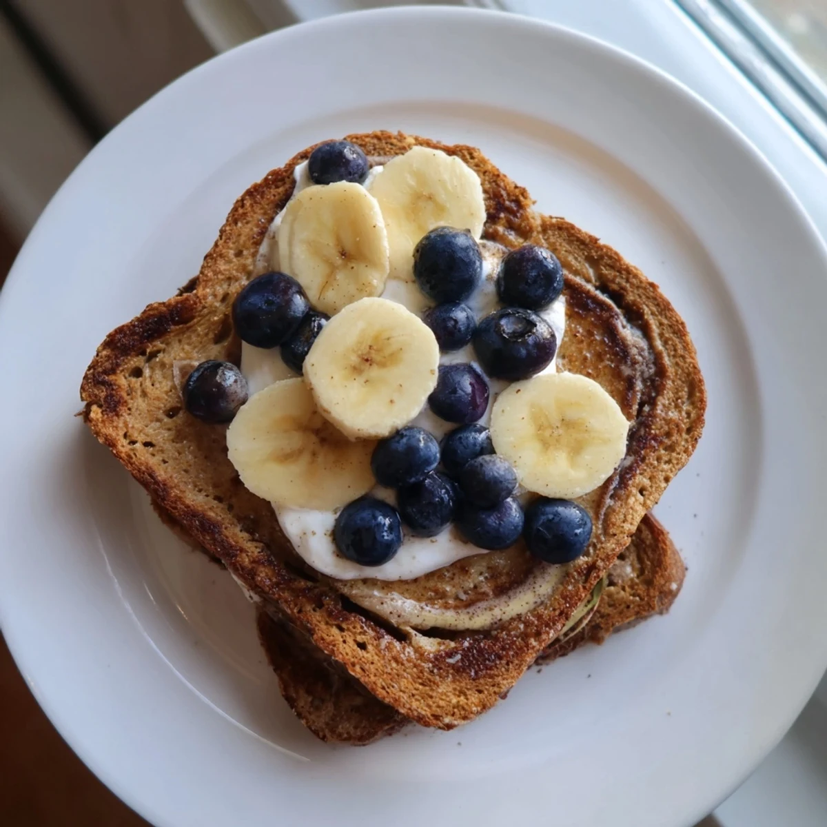Protein French Toast, golden-brown and fluffy, served with fresh berries and maple syrup for breakfast.