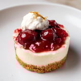 Close-up of creamy Kirsch-Rococo mini cheesecakes with a crunchy almond cookie crust visible.