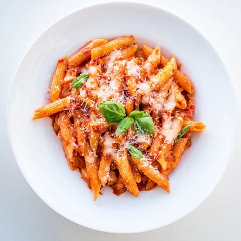 Baked Penne Arrabbiata, bubbling hot with melted cheese and a spicy, vibrant tomato sauce.