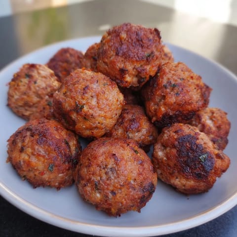Close-up of freshly cooked German Meatballs, sizzling in a skillet, perfect for dinner tonight.