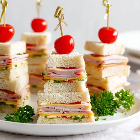 Savory ham and Swiss cheese mini sandwiches shaped as Christmas trees, ready to enjoy at a family gathering.