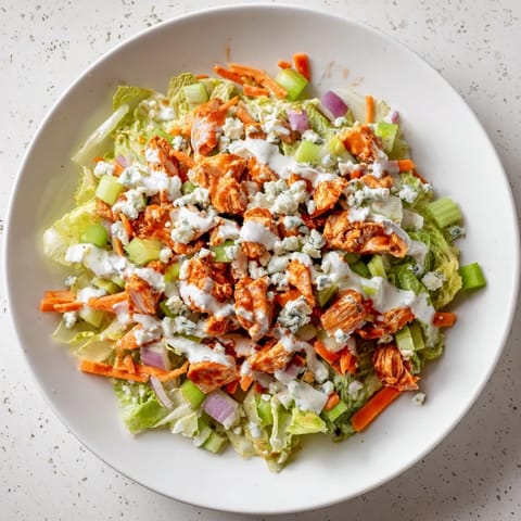 Frisch zusammengestellte Buffalo Chicken Chopped Salad mit würziger Hähnchen- und Blaukäse-Textur auf knackigem Salat.