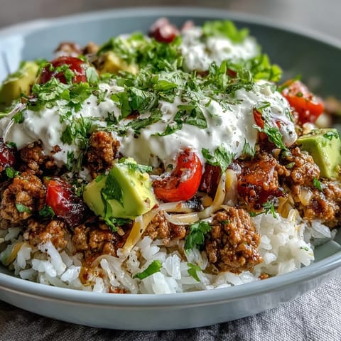 Hearty ground turkey seasoned with smoky spices fills this colorful Turkey Taco Bowl, garnished with fresh lettuce, tomatoes, and creamy sour cream.