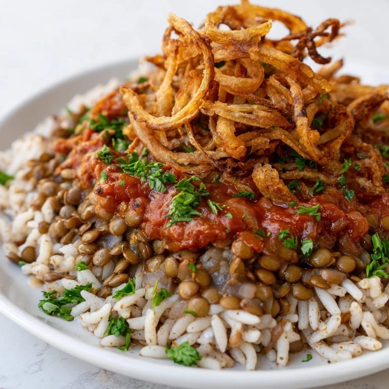Close-up of a serving of Egyptian Koshari, showcasing the layers of grains and lentils