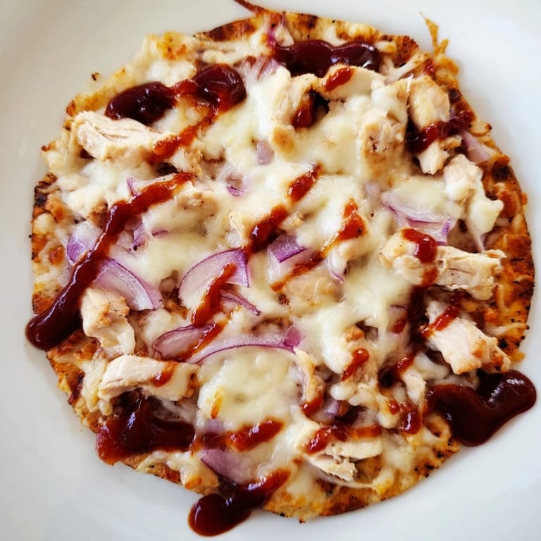BBQ Chicken Flatbread with drizzled sauce and fresh cilantro, served hot on a rustic wooden board.