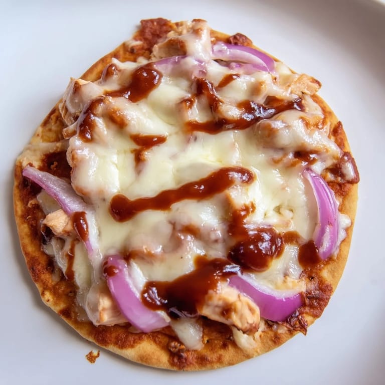 Golden BBQ Chicken Flatbread cut into wedges, featuring tangy sauce, tender chicken, and bubbly mozzarella.